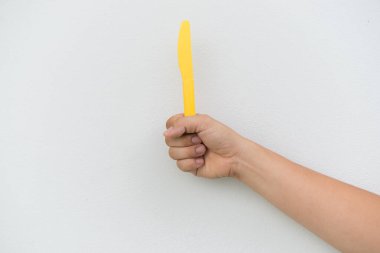 Beyaz arka planda sarı plastik bıçak
