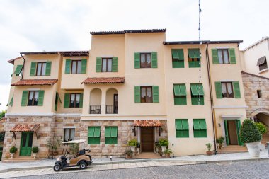 Toskana stili, önünde golf arabası olan bir bina, Toskana şehri.