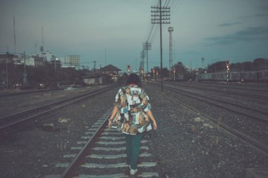 Demiryolunda poz veren Asyalı hippi kız, klasik tarz fotoğraf.