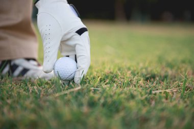 Golfçünün yakın eli çimenlerden, Taylandlılardan golf oynuyor.