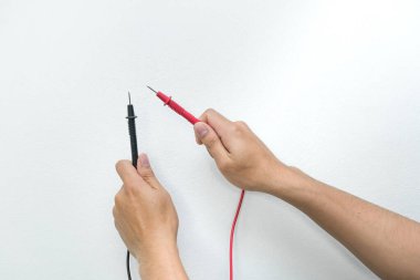 Beyaz arkaplanda ohmmetreden oluşan kırmızı ve siyah kablo
