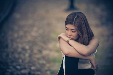 Portrait of lonely woman alone at the railway. Vintage filter style.she heartbreak from love,sad girl concept on sunset vintage style