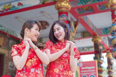 Cheongsam elbiseli iki güzel Asyalı kadının portresi, Tayland halkı, mutlu Çin yeni yılı konsepti.