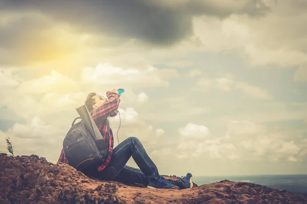 Asian handsome man alone on the mountain, Drink water after tired