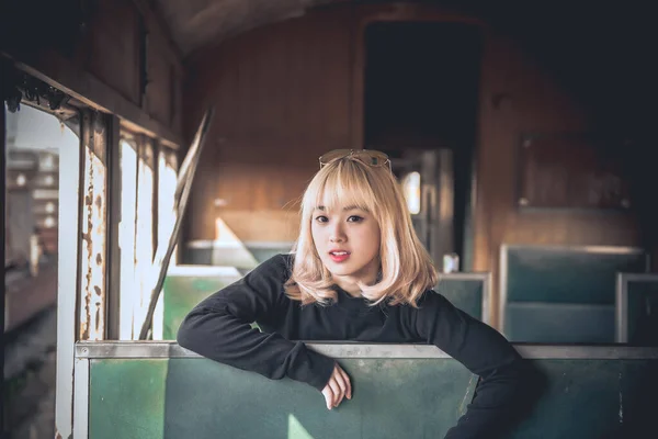 Portrait of asian woman golden hair pose for take a photo on old train vintage style,thailand people,Lifestyle of modern girl