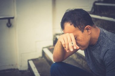 Asyalı, yakışıklı, sigara içen, Taylandlı, bunalımlı adam konsepti, şirketinin işi hakkında endişeleniyor.