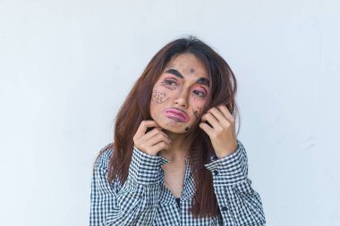 Güzel Asyalı kadın beyaz arka planda yüz esprisi yapıyor, Taylandlılar fotoğraf için poz veriyor.