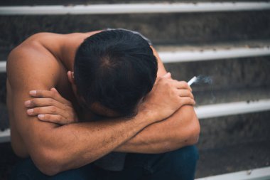 Asyalı, yakışıklı, sigara içen, Taylandlı, bunalımlı adam konsepti, şirketinin işi hakkında endişeleniyor.