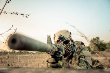 Sığınağın arkasında silahlı bir asker.