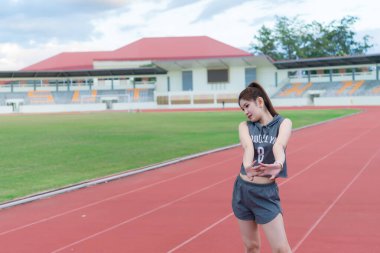 Asyalı zayıf kadın antrenmandan önce ısınıyor, zayıf kız hayat boyu egzersiz yapıyor, Taylandlılar, koşmadan önce vücudunu esnetiyorlar.