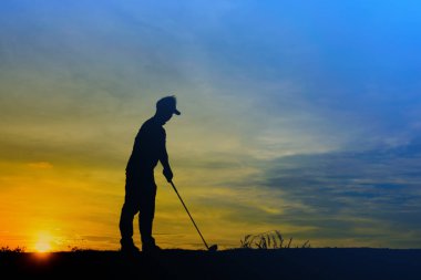 Siluet Asyalı golfçü güzel günbatımında golf oynuyor