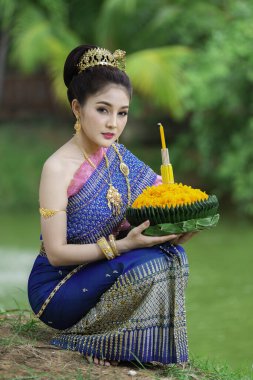 Tayland elbisesi içindeki güzel Asyalı kadın portresi geleneksel dua Kratong 'u, Tayland' da düzenlenen loy kratong festivaline katılması için tutuyor.
