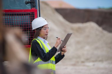 Tayland 'da büyük bir inşaat projesinin şantiyesinde çalışan Asyalı mühendis inşaat alanında fazla mesai yapıyor.