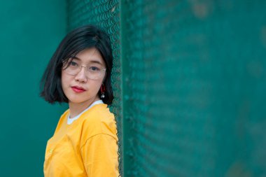 Güzel Asyalı şık bir kızın portresi fotoğraf çekmek için, Tayland 'lı gençlerin yaşam tarzı, modern kadın mutlu konsepti, tenis couse, pastel tonu