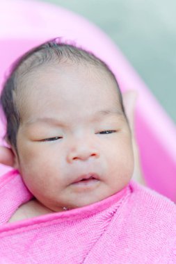 Pembe havluyla Asyalı bebek
