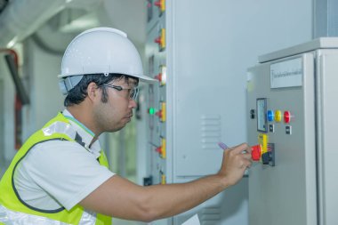 Asyalı elektrik mühendisi yakışıklı adam orta gerilimli şalter, körfez kontrol ünitesi, Taylandlı insanları kontrol et.