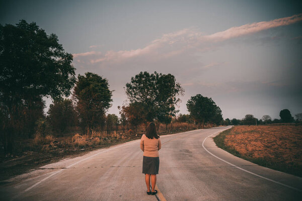 Portrait of lonely woman alone in a field. Vintage filter style.she heartbreak from love,sad girl concept on sunset vintage style