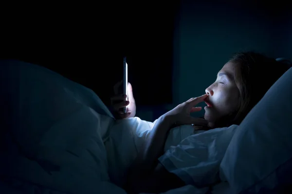 Asian woman play smartphone in the bed at night,Thailand people