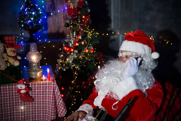 Angry Santa claus holding Shortgun at home,Sit on chair think about plan for sent gift box for give children