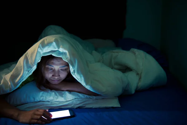 Asian woman play smartphone in the bed at night,Thailand people,Addict social media,Play internet all night