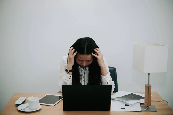 Businesswomanman stress from hard work on the desk at office dark tone,thailand people