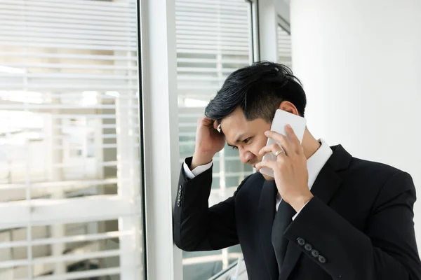 Asian businessman talk telephone with ceo company about work,he stress very much