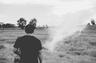 Fotoğrafçılık arka tarlalarda sigara içiyor.