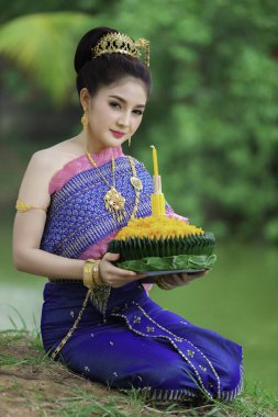 Tayland elbisesi içindeki güzel Asyalı kadın portresi geleneksel dua Kratong 'u, Tayland' da düzenlenen loy kratong festivaline katılması için tutuyor.