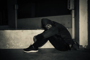 Asyalı üzgün bir adamın portresi, yerde oturan uyuşturucu bağımlısı, flakka ilacı, zombi uyuşturucusu