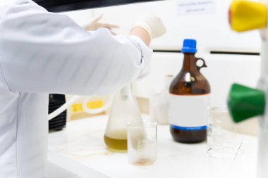 Laboratuvarda çalışan Asyalı bilim adamını kapatın, müşteri için deneyler yapın, formül kullanın.