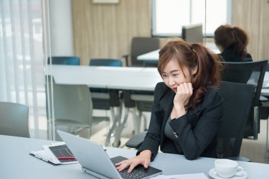 Güzel Asyalı kadın şirket için fazla mesai yapıyor.