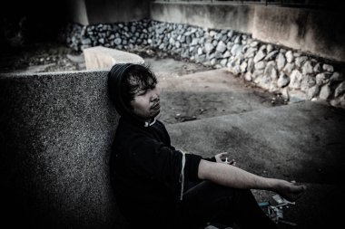 Asyalı adam siyah başlıklı umutsuz uyuşturucu bağımlısı, aşırı dozda uyuşturucu bağımlısı ve bilinç kaybı uyuşturucu ölüme, Taylandlılara, kan damarlarına eroin enjekte etmeye neden oluyor.