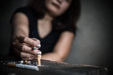Asyalı kadın sigarayı eliyle eziyor. Bağımlılık konseptini bırakıyorum. Tütün günü yok.