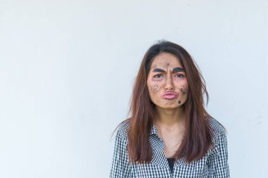 Güzel Asyalı kadın beyaz arka planda yüz esprisi yapıyor, Taylandlılar fotoğraf için poz veriyor.
