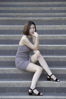 Asyalı kadın portresi yolda oturur, güzel Tayland halkı, mutlu kadın konsepti, modern kız yaşam tarzı...