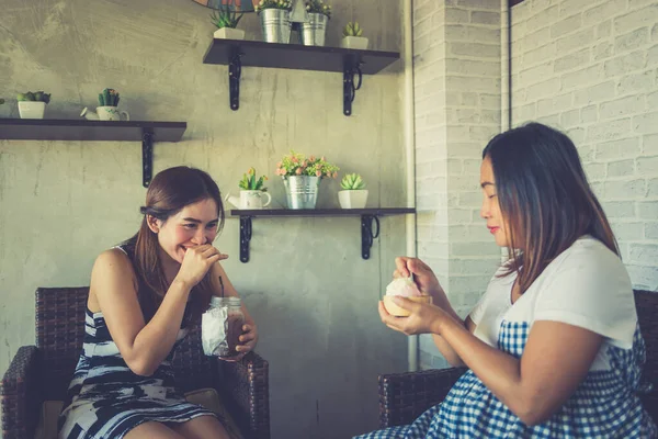 2人のアジア人女性がコーヒーショップで冗談話をして妊娠中の女性幸せなコンセプト — ストック写真