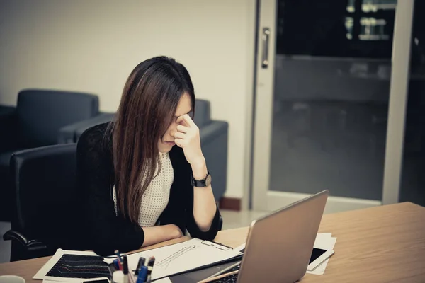 Asian businesswoman stress from hard work,Thai worker woman working in the office,Dark tone