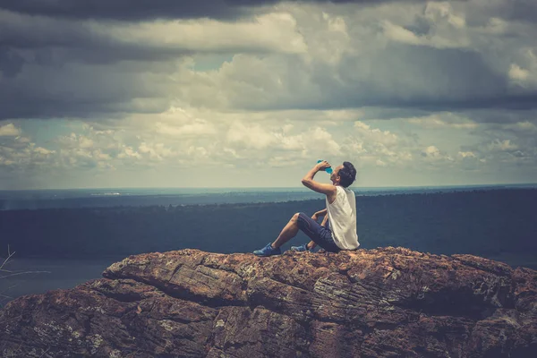 Asian handsome man alone on the mountain, Drink water after tired