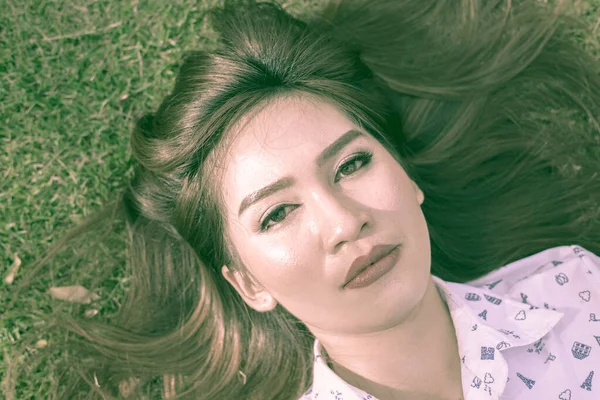 緑の草の上の若いアジア人女性の肖像画 — ストック写真