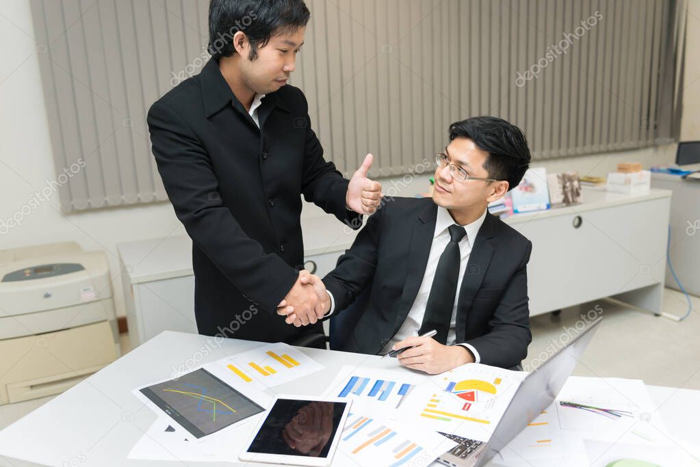 Two Asian businessmen success concept,Thailand employee happy from work finished,Shaking hands after finish work
