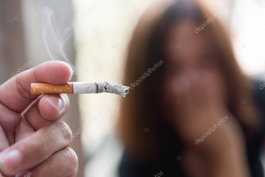 Passive smoking concept.Asian Man is smoking cigarette and woman is covering her face,No tobacco day,Smoking is objectionable to society,Thailand people