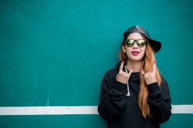 Asyalı hippilerin kızı fotoğraf çekiyor, modern kadının yaşam tarzı, hippi tarzı Taylandlı insanlar, altın saçlar, yeşil duvarda genç altın bir kadın.