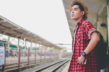 Asyalı turist tren istasyonunda bekler, Taylandlı hippi gezmeye gider.