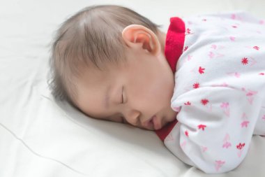 Asyalı bebek yatakta uzanıyor, şirin Tayland ve küçük kız.