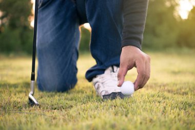 Asyalı bir golfçü çimlerde golf oynuyor, Tayland 'da insanlar golf oynuyor.