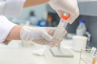 Bilim adamı deneyden önce kimyasalları sallama makinesiyle karıştırdı. Laboratuvarda çalışan Tayland 'lı bilim adamı test tüplerine numuneler karıştırdı.