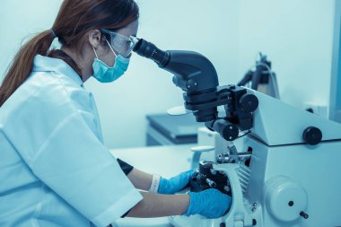 Laboratuvarda çalışan bayan Asyalı bilim adamı müşteri için formül kullanarak deney yapıyor.