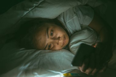 Asyalı kadın gece yatakta akıllı telefon çalar, Taylandlılar...
