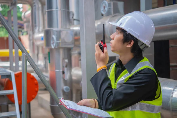 Asian Maintenance engineer at the waste water management system of a huge factory,maintenance checking technical data of heating system equipment,Thailand people