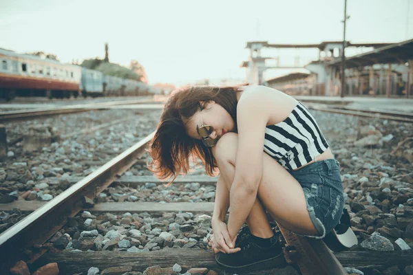 ヒップスターの女の子は 夕方には鉄道の方法で悲しい感じ日本語のトーン ヴィンテージスタイル ダークトン フィルム パステル — ストック写真